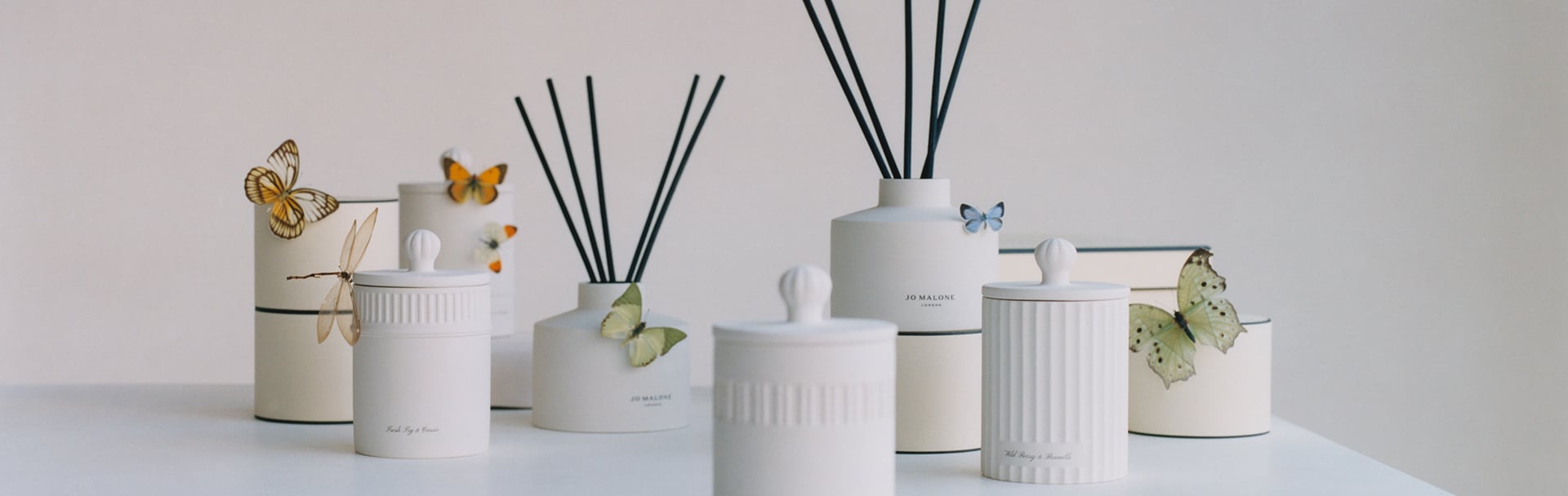 Afbeelding van schoorsteenmantel met Jo Malone reiskaars, diffuser, kaars & roomspray in een reeks geuren naast een buste